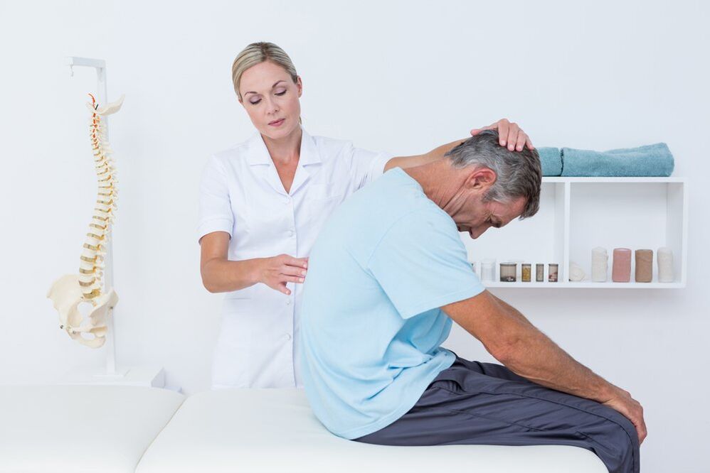 il medico esamina la schiena con osteocondrosi